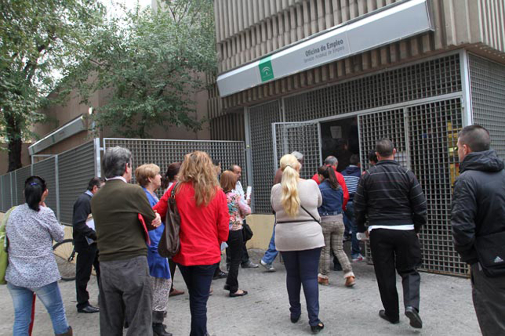 ¿Cuándo son los plenos en tu Ayuntamiento de Alcalá del Río? Foto de personas entrando en una oficina de empleo en Sevilla.