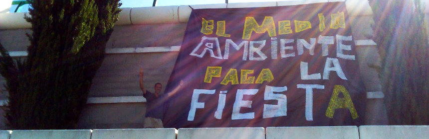 Compañeros de EQUO colocan una pancarta contra la 'huella' del festival 'Alrumbo'.